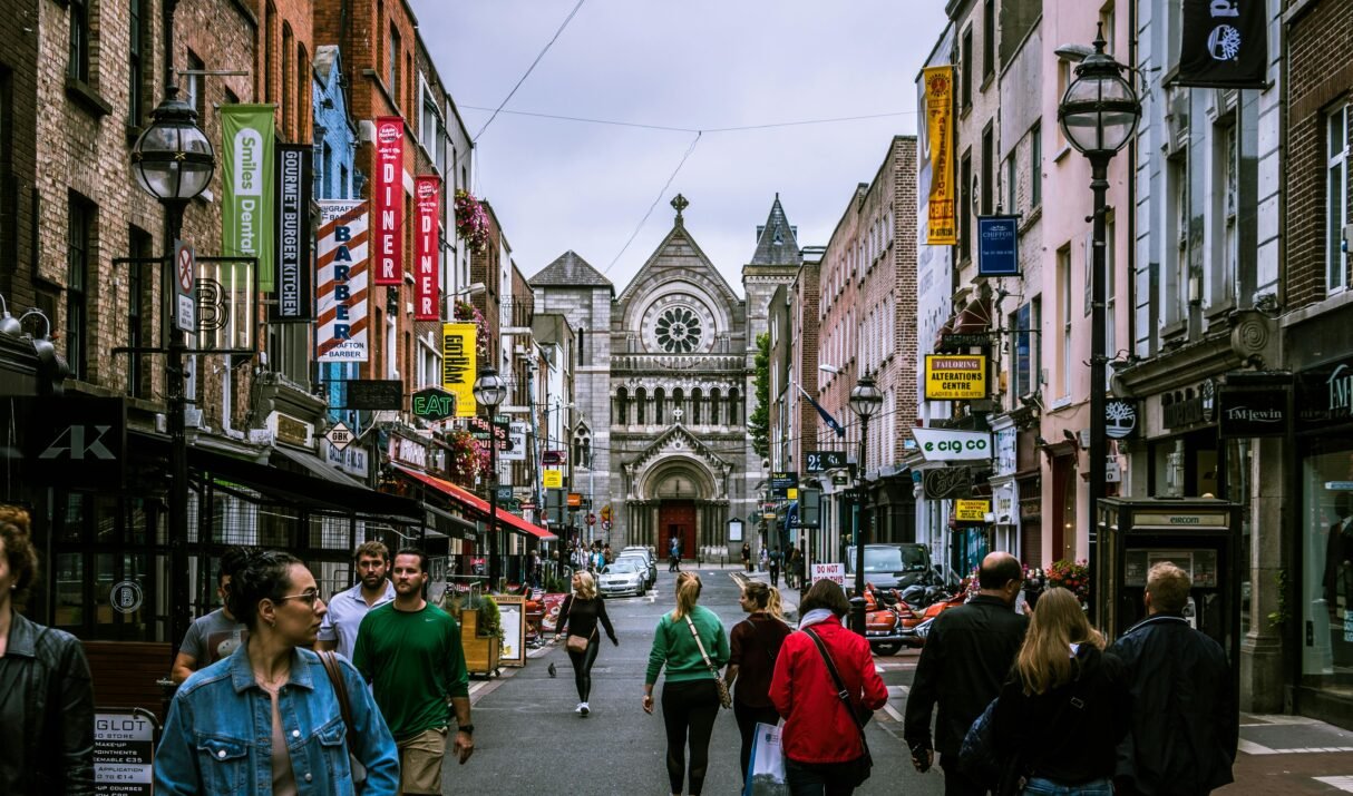 A bustling street scene in Dublin, showcasing diverse people and historic architecture.