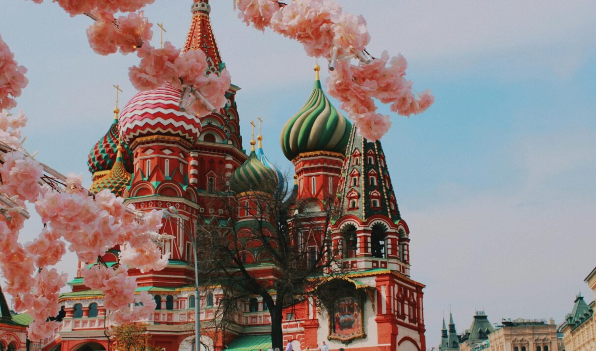 Saint Basil's Cathedral in Moscow framed by cherry blossoms, showcasing vibrant Russian architecture.