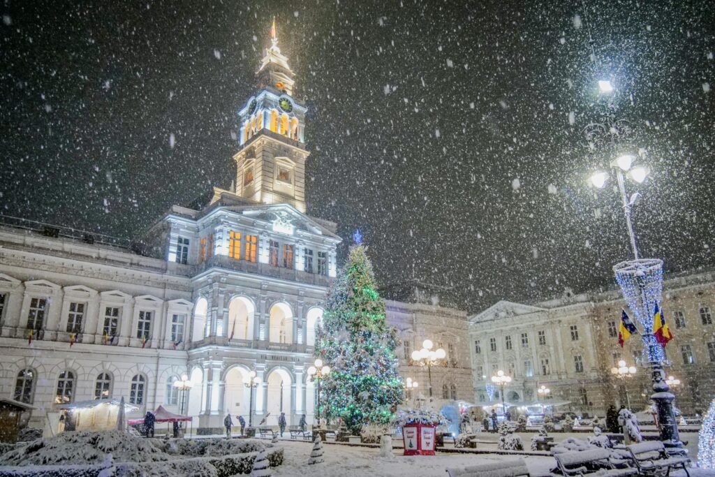 A beautiful winter scene in Arad, Romania, showcasing snowfall and festive Christmas lights.